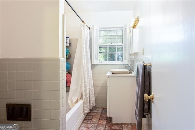 2620 Clairmont Rd, Atlanta, GA 30329 - bathroom with tile walls, shower / tub combo with curtain, vanity, stone finish floors, and a wainscoted wall