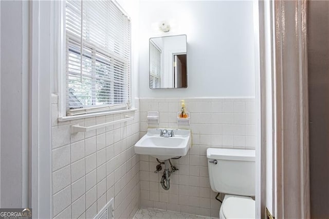2620 Clairmont Rd, Atlanta, GA 30329 - half bathroom with tile walls, toilet, a sink, and a wainscoted wall