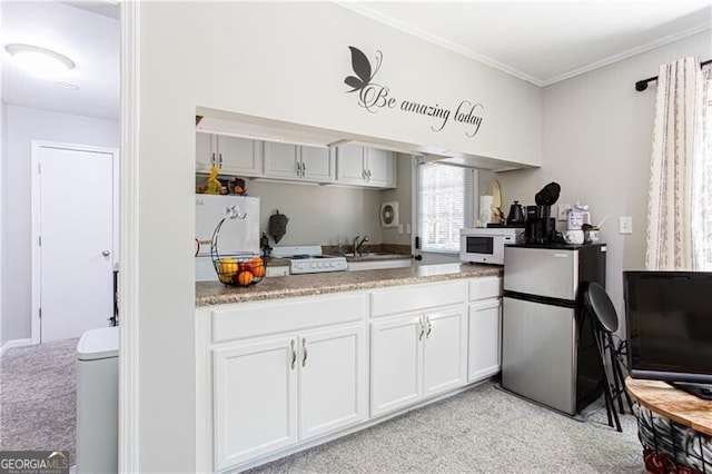 2620 Clairmont Rd, Atlanta, GA 30329 - kitchen featuring light colored carpet, white appliances, white cabinetry, crown molding, and a sink