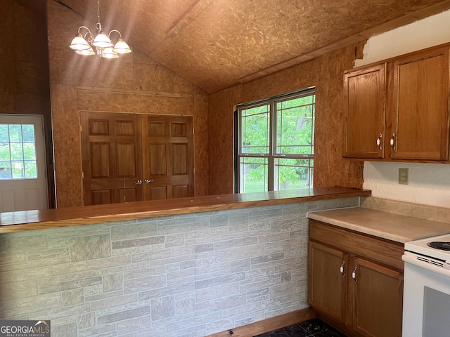 kitchen with electric range, brown cabinets, a chandelier, vaulted ceiling, and light countertops
