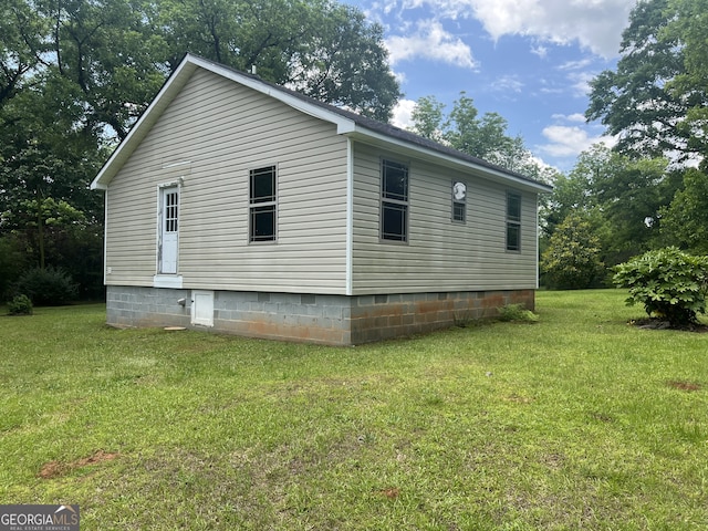 view of side of home with a lawn and crawl space