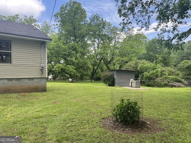 view of green lawn with an outdoor structure and a storage unit