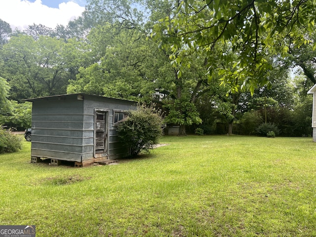 view of green lawn with a shed and an outdoor structure