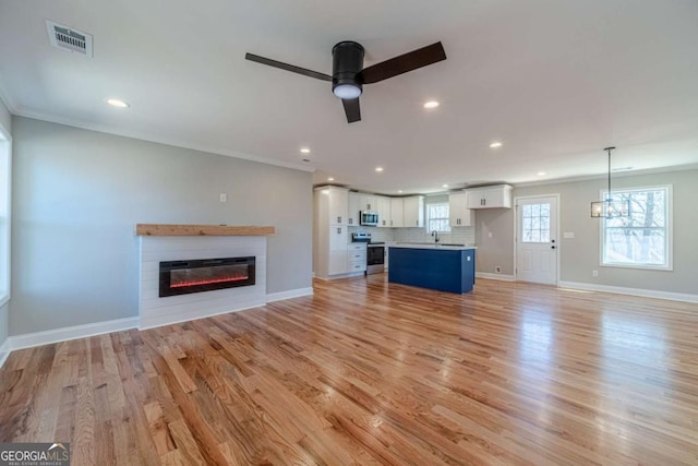 2741 Pierce Rd, Gainesville, GA 30507 - unfurnished living room featuring a glass covered fireplace, ceiling fan, light wood-style flooring, recessed lighting, and ornamental molding