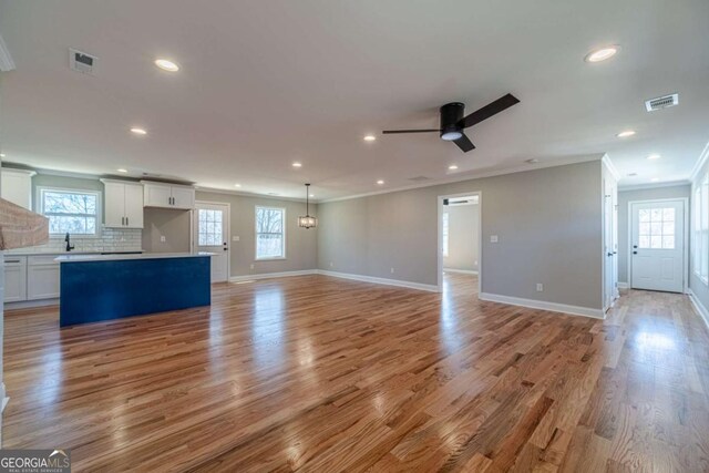 2741 Pierce Rd, Gainesville, GA 30507 - unfurnished living room featuring crown molding, recessed lighting, light wood-style floors, and baseboards