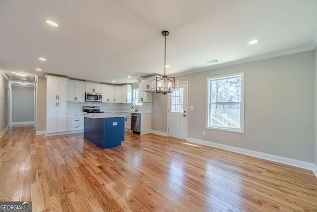 2741 Pierce Rd, Gainesville, GA 30507 - kitchen featuring appliances with stainless steel finishes, ornamental molding, white cabinetry, a kitchen island, and recessed lighting