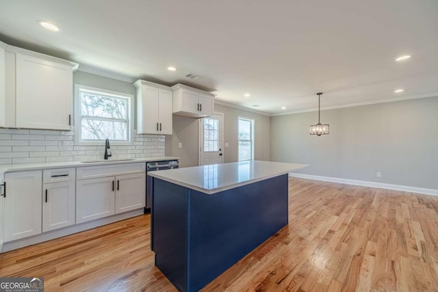 2741 Pierce Rd, Gainesville, GA 30507 - kitchen with a sink, ornamental molding, white cabinetry, light wood-style flooring, and decorative backsplash