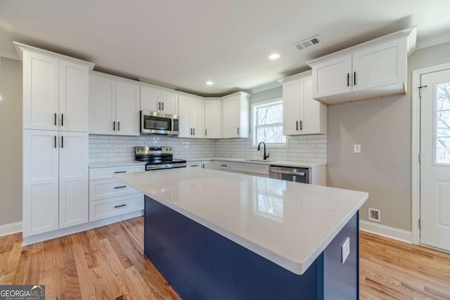 2741 Pierce Rd, Gainesville, GA 30507 - kitchen featuring stainless steel appliances, light wood-style flooring, white cabinets, recessed lighting, and ornamental molding
