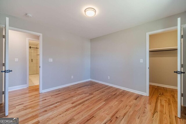 2741 Pierce Rd, Gainesville, GA 30507 - unfurnished bedroom with light wood-style floors, a walk in closet, baseboards, and a closet