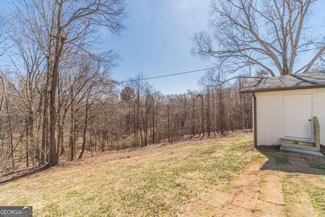 2741 Pierce Rd, Gainesville, GA 30507 - view of green lawn featuring a wooded view and an outdoor structure