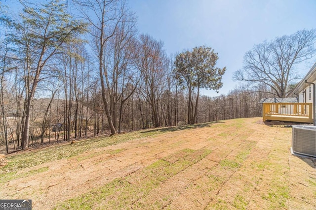 2741 Pierce Rd, Gainesville, GA 30507 - view of grassy yard featuring a wooden deck, central AC unit, and a wooded view