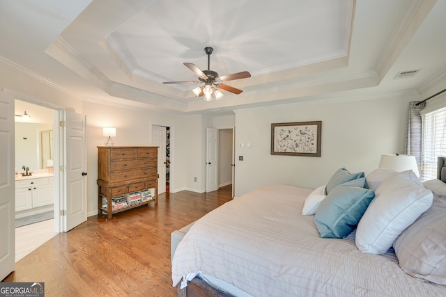 6009 Castleton Mnr, Cumming, GA 30041 - bedroom featuring a raised ceiling, crown molding, light wood finished floors, a sink, and connected bathroom
