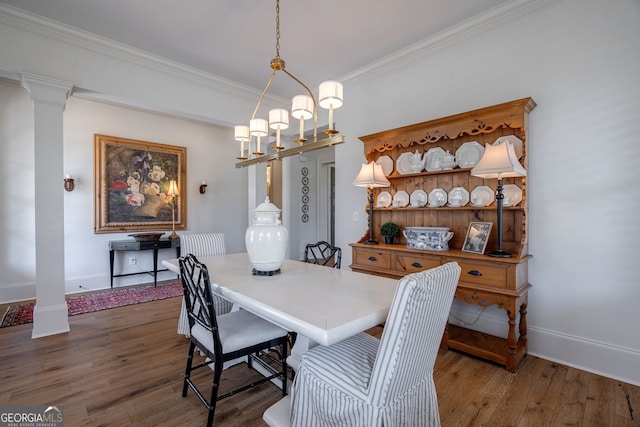 2970 Greenleffe Dr, Statham, GA 30666 - dining area featuring wood finished floors, ornamental molding, baseboards, and ornate columns