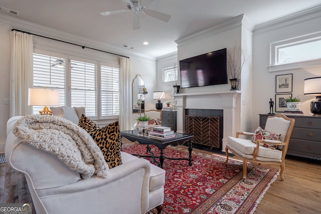 2970 Greenleffe Dr, Statham, GA 30666 - living room featuring healthy amount of natural light, crown molding, wood finished floors, a fireplace with flush hearth, and ceiling fan