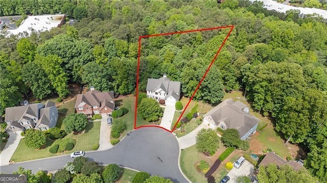 aerial view of residential area featuring property boundaries highlighted and a forest