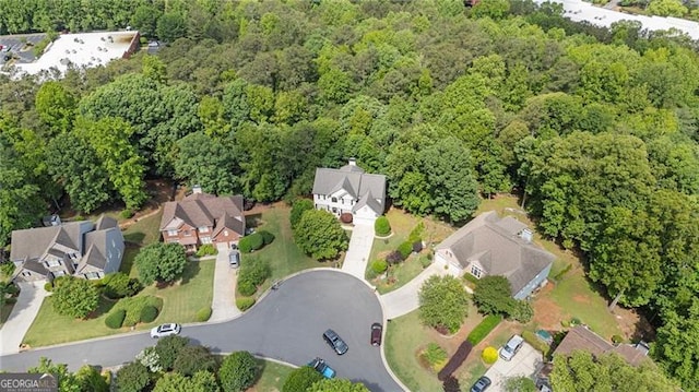 aerial view of property's location with a heavily wooded area and nearby suburban area