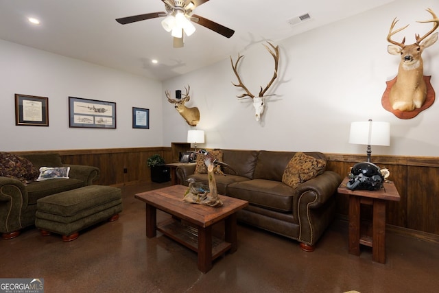 living room with a wainscoted wall, a ceiling fan, recessed lighting, and wood walls