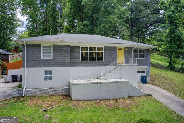 2564 Riggs Dr, East Point, GA 30344 - single story home featuring an attached garage, stairway, driveway, a front yard, and brick siding