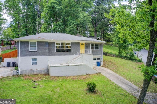 2564 Riggs Dr, East Point, GA 30344 - view of front of home featuring stairs, a front yard, concrete driveway, brick siding, and view of scattered trees