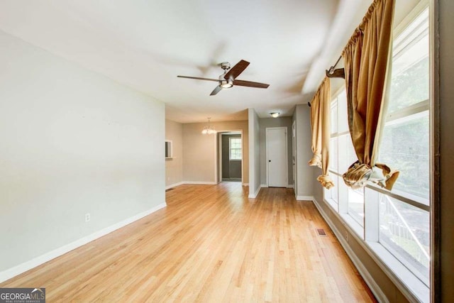 2564 Riggs Dr, East Point, GA 30344 - spare room with light wood-style floors, a ceiling fan, and a chandelier