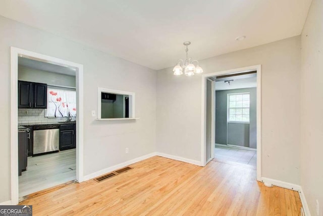2564 Riggs Dr, East Point, GA 30344 - unfurnished dining area with a chandelier and light wood-style floors