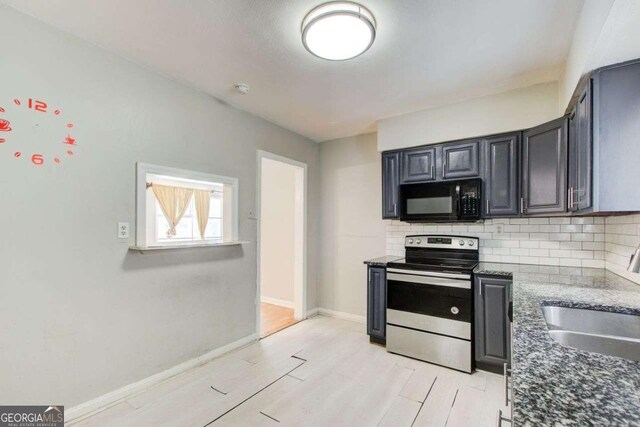 2564 Riggs Dr, East Point, GA 30344 - kitchen featuring stainless steel range with electric cooktop, black microwave, tasteful backsplash, dark stone counters, and light wood-style flooring