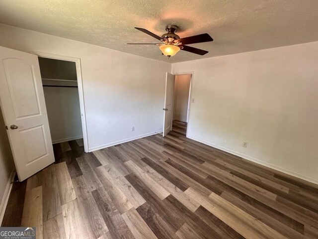 2872 Harris St, Atlanta, GA 30344 - unfurnished bedroom with dark wood-type flooring, a textured ceiling, baseboards, a closet, and ceiling fan