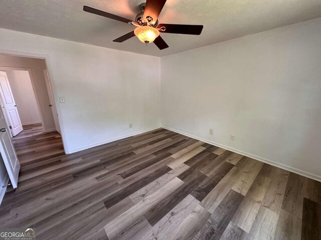 2872 Harris St, Atlanta, GA 30344 - unfurnished room with ceiling fan, dark wood finished floors, baseboards, and a textured ceiling
