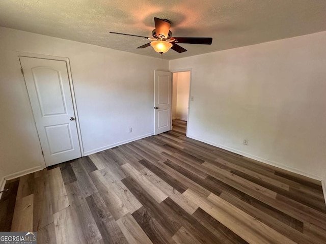 2872 Harris St, Atlanta, GA 30344 - unfurnished bedroom with dark wood-style floors, baseboards, a textured ceiling, and ceiling fan