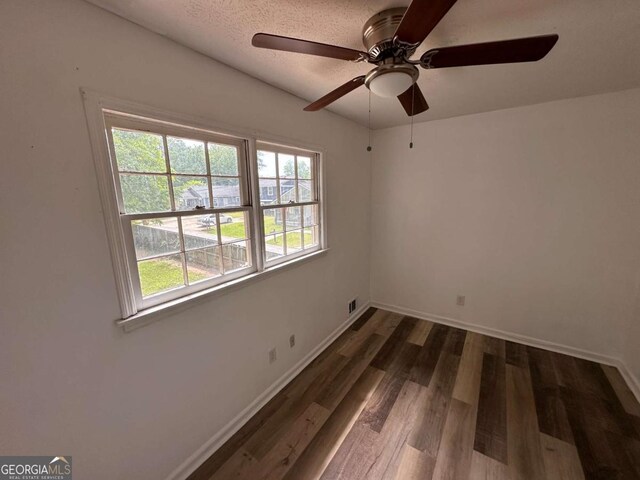 2872 Harris St, Atlanta, GA 30344 - unfurnished bedroom with dark wood-style floors, baseboards, a textured ceiling, and ceiling fan