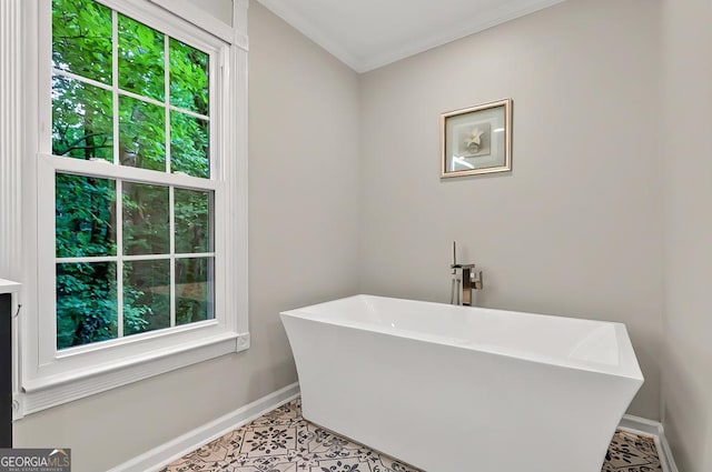bathroom with baseboards, healthy amount of natural light, a freestanding bath, ornamental molding, and tile patterned floors