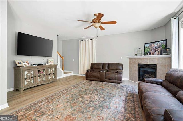 40 Boulder Ct, Dallas, GA 30132 - living area featuring stairway, a ceiling fan, a tiled fireplace, wood finished floors, and baseboards