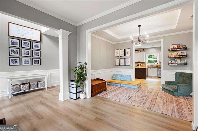 40 Boulder Ct, Dallas, GA 30132 - sitting room featuring light wood-style flooring, a chandelier, a decorative wall, a raised ceiling, and decorative columns