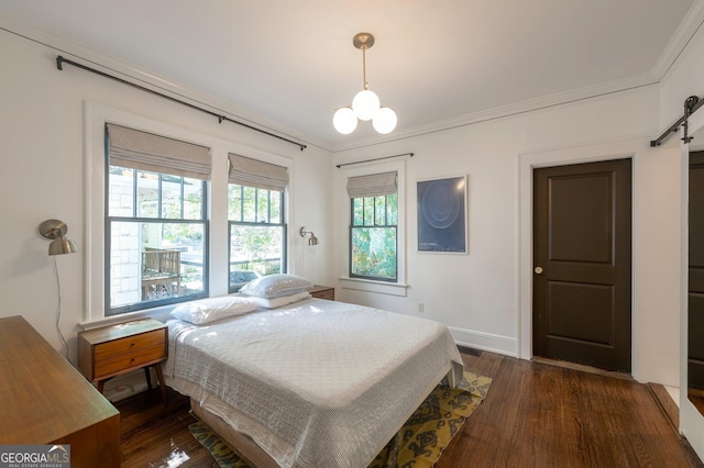 1231 Mansfield Ave NE, Atlanta, GA 30307 - bedroom with dark wood-style flooring, a chandelier, crown molding, a barn door, and baseboards