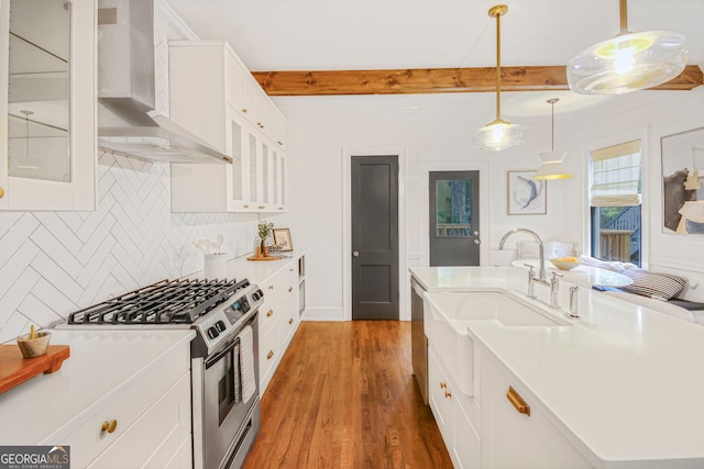 1231 Mansfield Ave NE, Atlanta, GA 30307 - kitchen with wall chimney exhaust hood, appliances with stainless steel finishes, backsplash, wood finished floors, and glass insert cabinets