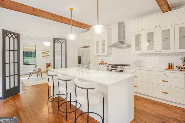 1231 Mansfield Ave NE, Atlanta, GA 30307 - kitchen with wall chimney exhaust hood, stainless steel gas range oven, beam ceiling, high quality fridge, and backsplash