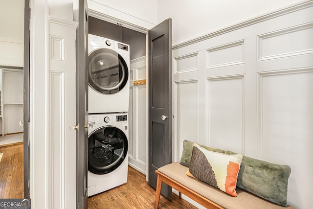 1231 Mansfield Ave NE, Atlanta, GA 30307 - washroom with stacked washer / dryer, light wood-type flooring, and a decorative wall