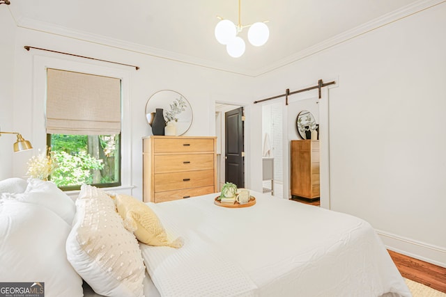 1231 Mansfield Ave NE, Atlanta, GA 30307 - bedroom with a chandelier, crown molding, wood finished floors, and a barn door