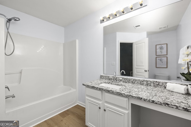 4457 Watson Ridge Dr, Stone Mountain, GA 30083 - bathroom with wood finished floors, toilet, vanity, bathtub / shower combination, and baseboards