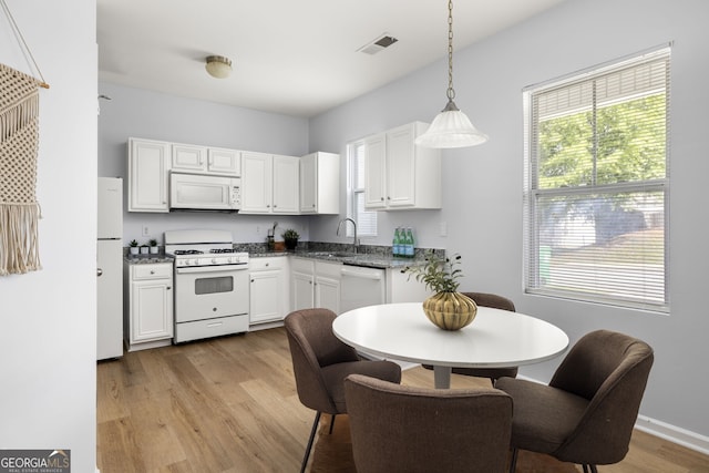 4457 Watson Ridge Dr, Stone Mountain, GA 30083 - kitchen with white appliances, light wood-style floors, white cabinetry, and decorative light fixtures