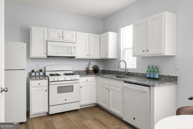 4457 Watson Ridge Dr, Stone Mountain, GA 30083 - kitchen featuring white appliances, a sink, white cabinets, wood finished floors, and dark stone counters