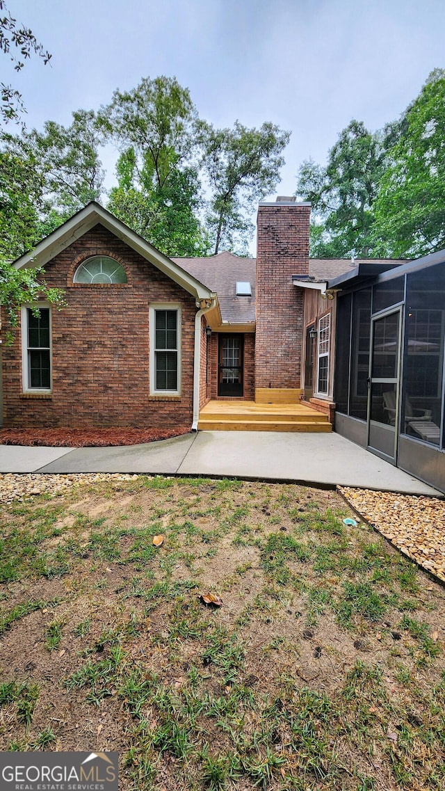 213 Falcon Crst, Warner Robins, GA 31088 - rear view of property with a chimney, a patio, a sunroom, and brick siding