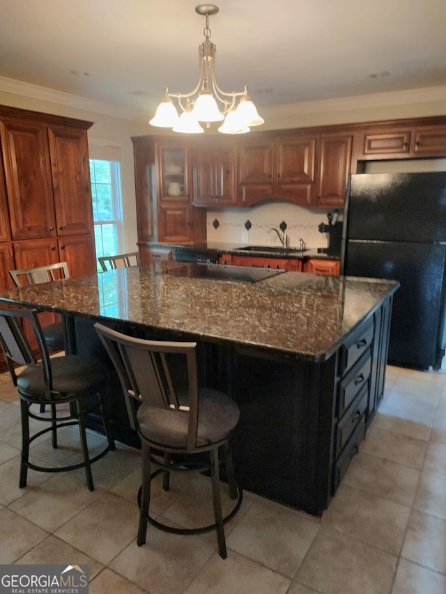 213 Falcon Crst, Warner Robins, GA 31088 - kitchen with freestanding refrigerator, a sink, a breakfast bar area, a chandelier, and light tile patterned flooring