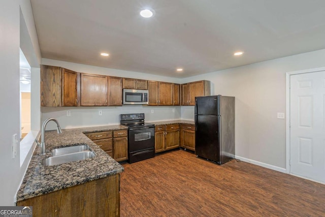 1808 Arkose Dr SE, Atlanta, GA 30316 - kitchen featuring black appliances, a sink, brown cabinets, dark stone counters, and recessed lighting