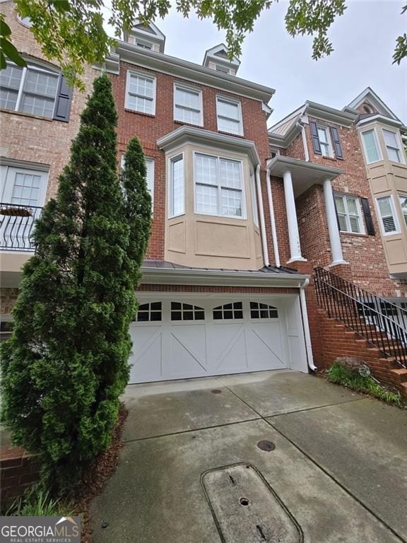 1042 Emory Parc Pl, Decatur, GA 30033 - view of property featuring brick siding, driveway, and an attached garage