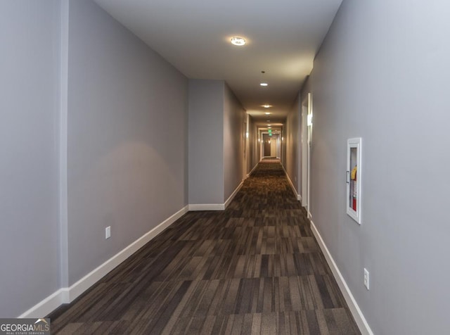 hallway with dark wood-style floors and baseboards