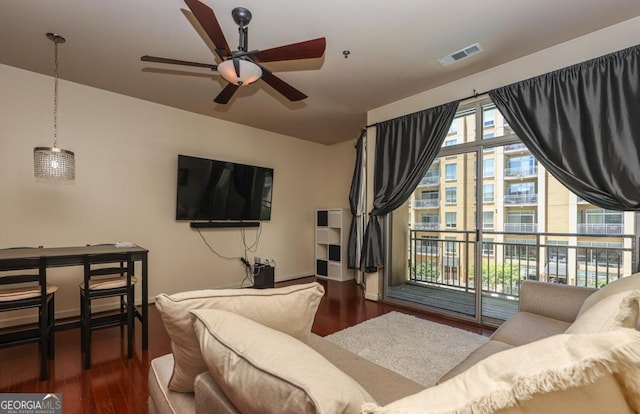 living room with a ceiling fan, wood finished floors, and baseboards