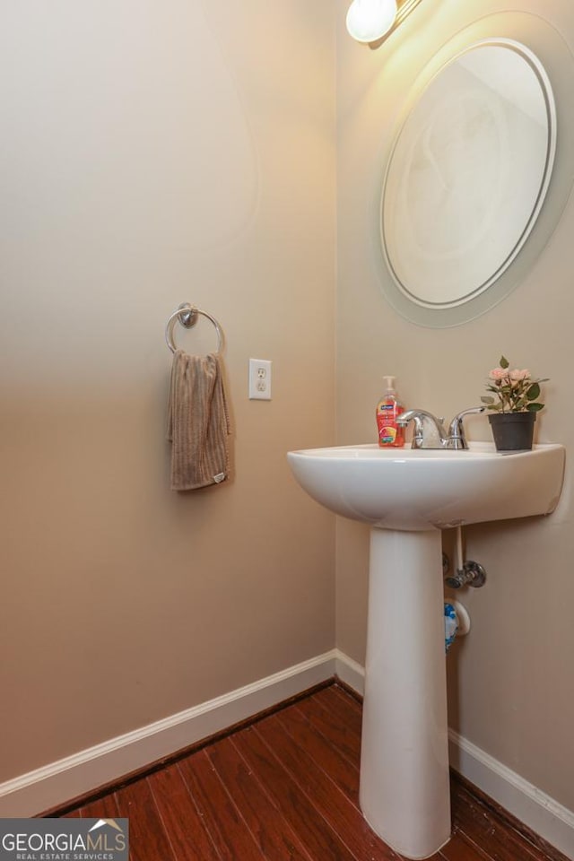 bathroom with baseboards and wood finished floors