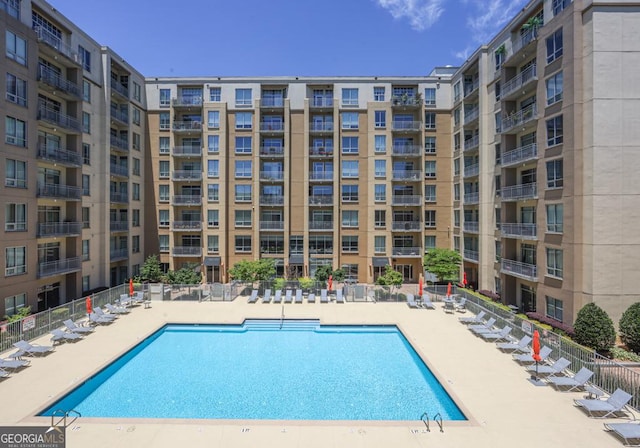 community pool featuring fence and a patio