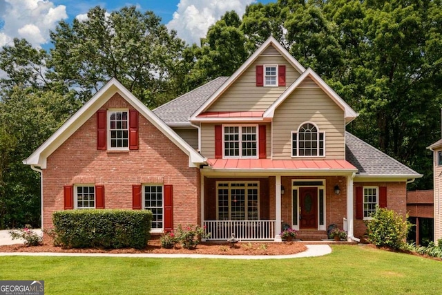 2430 Harbin Springs Cv, Dacula, GA 30019 - view of front of home with brick siding, covered porch, a front yard, and roof with shingles